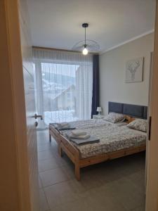 1 dormitorio con cama y ventana grande en Domki Piecykowo, en Międzybrodzie Żywieckie