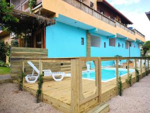 a house with a wooden fence and a pool at Pousada Astral in Imbituba