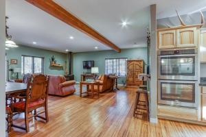 a living room with green walls and wooden floors at Spacious Three Rivers Lodge✦Fenced .5 Acre✦Hot Tub in Bend