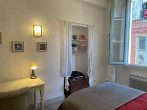 a bedroom with a bed and a desk and a window at In the heart of Old Nice - 2min. from Cours Saleya and Promenade des Anglais in Nice