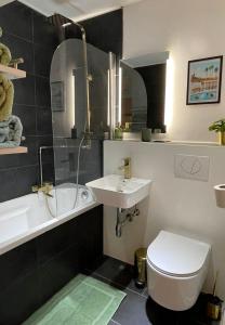 ein Badezimmer mit einem Waschbecken, einem WC und einer Badewanne in der Unterkunft Skyline Apartment Belle Vue in Karlsruhe