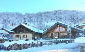 un edificio cubierto de nieve con una valla en Chalet La Plagne jacuzzi vue top, en Montchavin