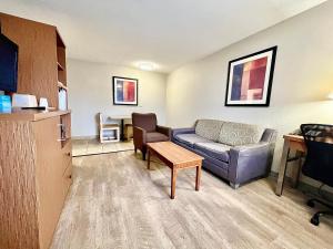un salon avec un canapé et une table dans l'établissement Days Inn & Suites by Wyndham Arlington Near Six Flags, à Arlington