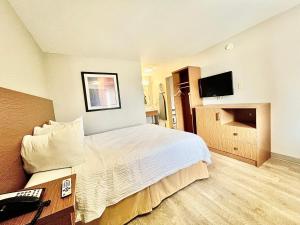 Habitación de hotel con cama y TV en Days Inn & Suites by Wyndham Arlington Near Six Flags, en Arlington