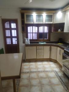 una cocina con armarios blancos y una mesa. en A 4 cuadras del ORFEO Alto verde 2 dormitorios en Córdoba