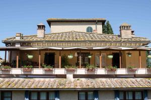 a building with potted plants on a balcony at Casa Vacanze Rondini Blu in Montespertoli