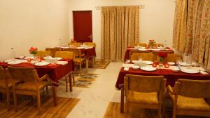 a dining room with tables and chairs with red tablecloths at Wow Relish in Alwar