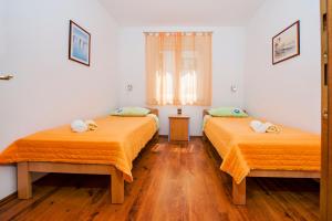 two beds in a room with wooden floors at Apartments Bella B in Rovinj