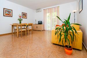 a living room with a yellow couch and a table at Apartments Bella B in Rovinj