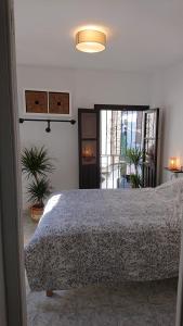 Casa Carmen في غرناطة: غرفة نوم بسرير في غرفة بها نباتات