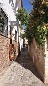 un callejón con un letrero de calle en el lateral de un edificio en Casa Carmen, en Granada