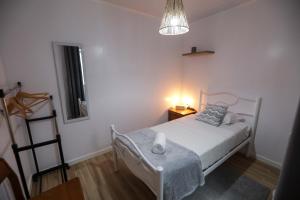 1 dormitorio con 1 cama y 1 mesa con lámpara en Tesouro do Atlântico, en Ponta Delgada