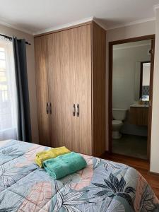 a bedroom with a bed with a cabinet and a bathroom at Casa Sector Oriente Talca in Talca
