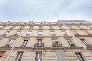 - un grand bâtiment avec des fenêtres et des balcons dans l'établissement SUITE RAPHAEL Tour Eiffel, à Paris