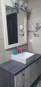 ein Badezimmer mit einem weißen Waschbecken und einem Spiegel in der Unterkunft Jade Aparts Salinas in Salinas