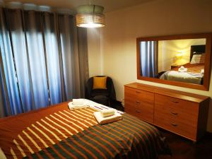 a bedroom with a bed with a dresser and a mirror at The Market Square House in Faro