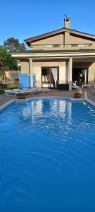 een groot blauw zwembad voor een huis bij Villa Alba cerca de Sitges in Canyelles