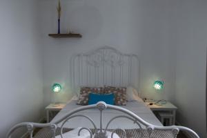 een slaapkamer met een wit bed met blauwe kussens bij Estrela do Atlântico in Ponta Delgada +21 foto's