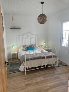 een slaapkamer met een wit bed en een hanglamp bij Estrela do Atlântico in Ponta Delgada