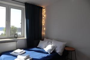 ein Schlafzimmer mit einem blauen Bett und einem Fenster in der Unterkunft FraToLe in Nielisz