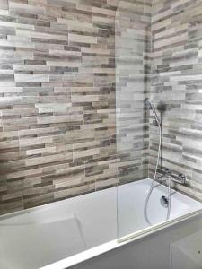 a bathroom with a tub with a glass shower at Villa Exceptionnelle Piscine et Jardin privé Séjour Haut de gamme proche La Rochelle in Sainte-Soulle
