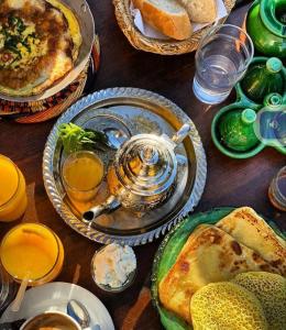 a wooden table with plates of food and drinks at Riad dar Ahlam in Aït Baha