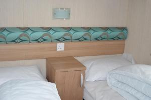 a bedroom with two beds and a desk with a mirror at Bobby's Bolthole in Heysham