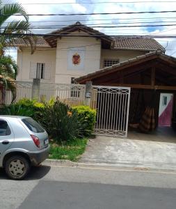Hospedagem Maria Joana في أتيبايا: ركن السيارة أمام المنزل