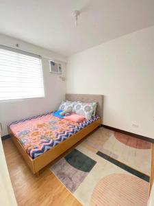 - une chambre avec un lit et des oreillers dans l'établissement Minimalist 1-bedroom condo unit CASA TIMMY, à Davao