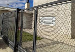 una valla de cadena frente a un edificio en Departamento full con estacionamiento privado en Río Gallegos