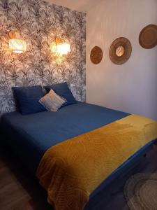 - une chambre dotée d'un lit avec des draps bleus et jaunes dans l'établissement Brin de Pause, 