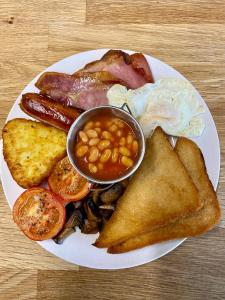 a plate of breakfast food with eggs sausage beans and toast at Gwynfryn Guest House in Pembrokeshire