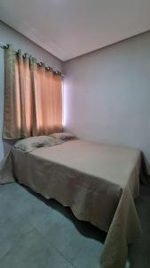 um quarto com uma cama grande e uma janela em Apartamento Sossego em Luís Correia
