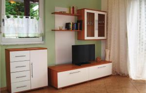 ein Wohnzimmer mit einem TV auf einer Kommode in der Unterkunft Ferienhaus Seeblick H in Herzsprung