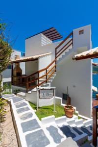 a white house with stairs in front of it at Villa Orion in Arraial do Cabo