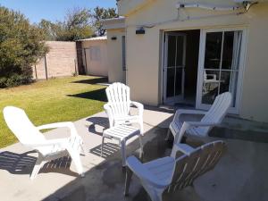 a group of white chairs sitting on a patio at Sierras de La Punta in La Punta