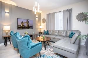 uma sala de estar com um sofá, cadeiras e uma mesa em Luxurious 4Bd Home w/ Pool 4983 em Kissimmee