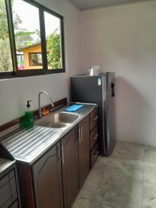 a kitchen with a sink and a refrigerator at Casa vista de luna in Guaria