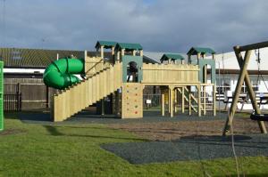 a playground with a green slide in a park at Bobby's Bolthole in Heysham