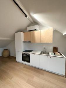 - une cuisine avec des placards blancs et un évier dans l'établissement Duplex hyper centre, à Liège
