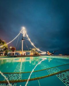 una mujer nadando en una piscina por la noche en Hosteria Farallon Dillon en Ballenita