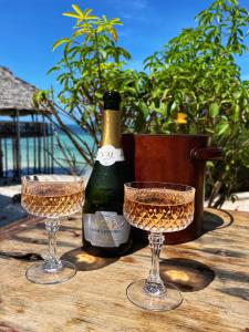 a bottle of champagne and two glasses on a table at Z-Lodge Zanzibar in Kiwengwa