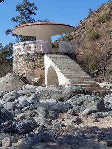 a building on a hill with a bunch of rocks at La Soñada II in Alta Gracia