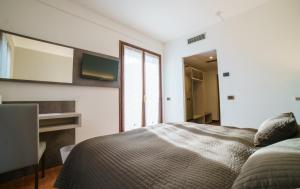 a bedroom with a bed and a large window at Hotel Lago Bin in Rocchetta Nervina