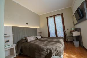 a bedroom with a large bed and a window at Hotel Lago Bin in Rocchetta Nervina