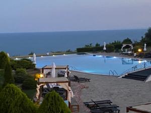 a large swimming pool with the ocean in the background at Kaliakria Infinity Pool Apartment in Topola