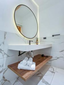 a bathroom with a mirror and towels on a wooden shelf at Wanderlot - Hotel Plaza Central in Riobamba +77 photos