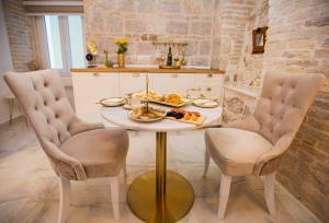 een tafel met een bord eten en twee stoelen bij Guest House Paradise in Split