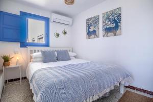 a bedroom with a bed with blue and white sheets at Casa Corbeto 43 in Cómpeta