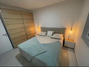 - une petite chambre avec un lit et un placard dans l'établissement Luxury Apartment SWANY, à Crikvenica